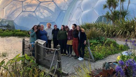 A women's leadership retreat group smiling in front of the Biomes